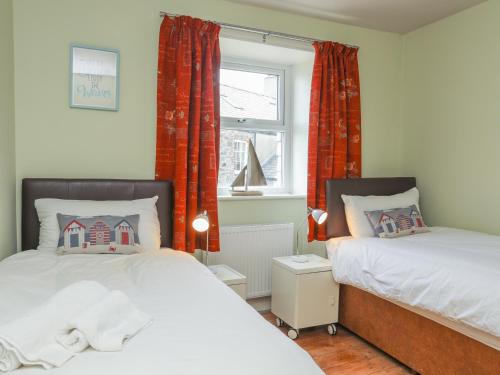 波马利斯Gadlys House - Beau View的一间卧室设有两张床和窗户。