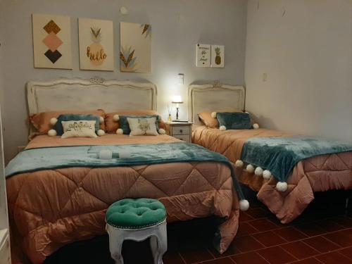圣洛伦索Apart La Nona的一间带两张床和凳子的卧室