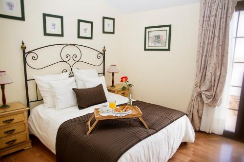 圣米格尔德阿沃纳球道俱乐部酒店的一间卧室配有一张床,上面放着一个食物托盘