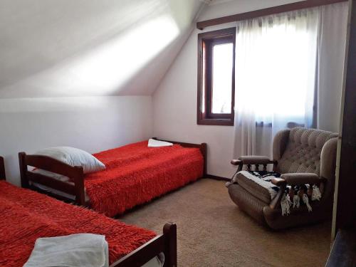 扎布利亚克Old Guest House 1964的一间卧室设有两张床、一把椅子和一个窗户。