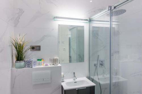 华沙Apartament Koszykowa Latwiec的白色的浴室设有水槽和淋浴。
