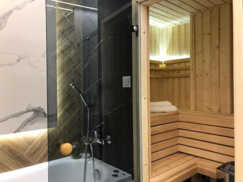 凯尔采Family & Business Sauna Apartments Plac Wolności CENTRUM Downtow, UNIKAT - 5 Bedroom with Private Sauna, Bath with Hydromassage, Parking, Catering Options的浴室配有浴缸、淋浴和水槽