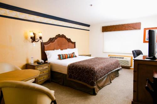 华雷斯城玛丽亚博尼塔商务套房酒店的配有一张床和一把椅子的酒店客房