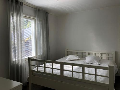 于韦斯屈莱Villa Kalliorinne的白色的卧室设有床和窗户