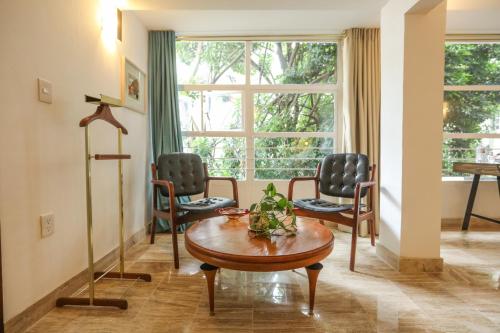 墨西哥城伯爵夫人酒店的客厅配有两把椅子和一张桌子
