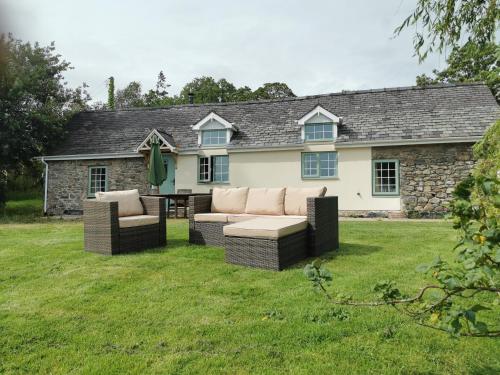 纽敦Lletty Ann wynn at Fraithwen Cottages的院子里有两张沙发的房子