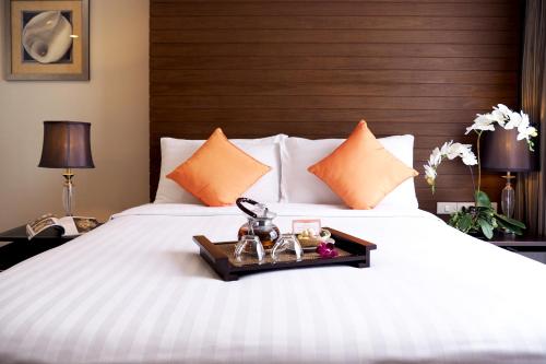 曼谷西隆富丽萨通酒店的卧室配有白色的床和木制床头板