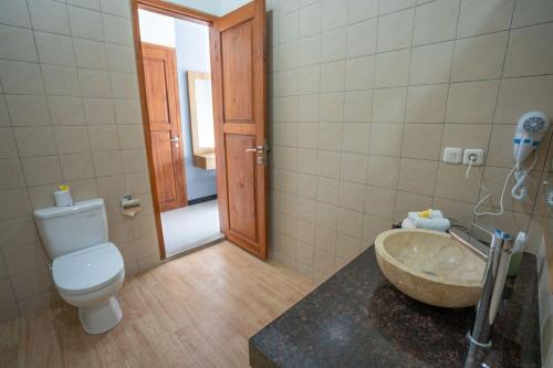 图兰奔巴厘岛潜水度假及Spa酒店的浴室配有盥洗盆、卫生间和浴缸。