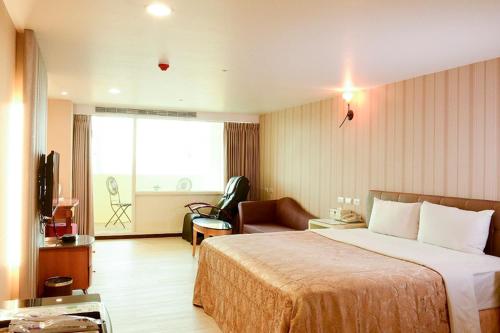 Xinfeng青叶大旅馆的酒店客房带一张大床和一把椅子