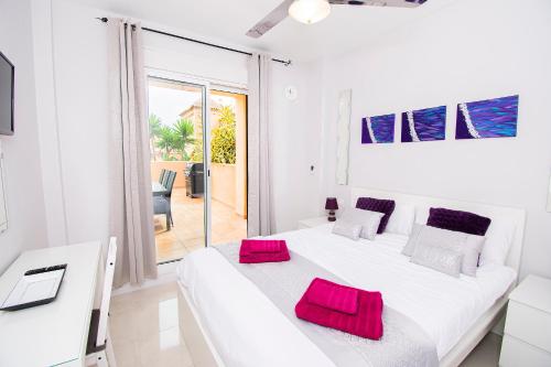 福恩吉罗拉Alta Loma Costa的白色卧室配有一张带红色枕头的大白色床