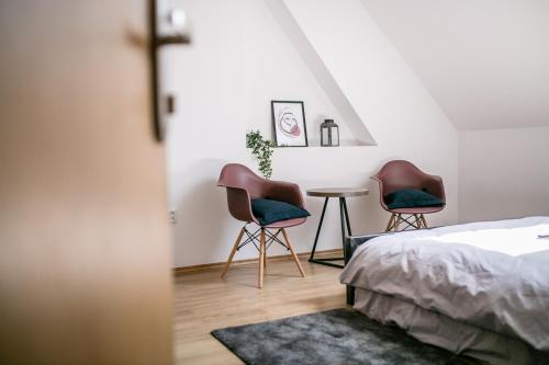布拉迪斯拉发Schöndorf Hostel - virtual reception的一间卧室配有两把椅子和一张桌子