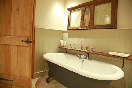 福梅尔La Grange dans la Foret的带浴缸、水槽和镜子的浴室
