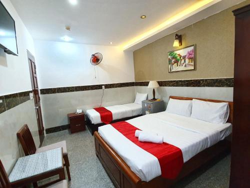 胡志明市张江酒店的酒店客房,配有两张床和椅子