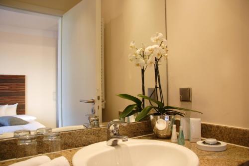 巴德索登陶努斯卓悦酒店的浴室设有水槽和花瓶