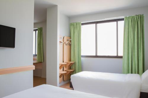 布拉加布拉加中心宜必思快捷酒店的酒店客房设有两张床和窗户。