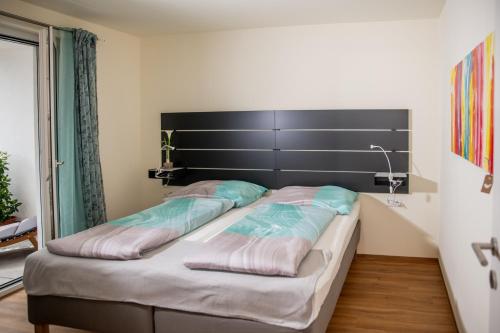 多恩比恩Cityapartment Dornbirn 50 qm的一间卧室配有一张大床和黑色床头板