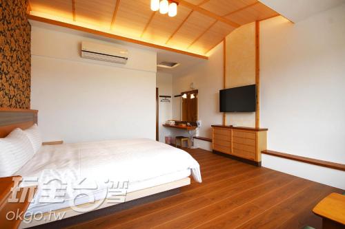 鹿谷乡豆田町的一间卧室配有一张床和一台平面电视