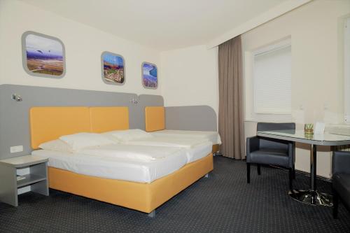 汉堡库克皮特酒店的一间卧室配有一张床、一张桌子和一张桌子