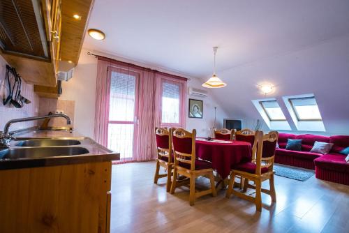 豪伊杜索博斯洛Kis-Gast Panoráma Apartman的厨房以及带红色桌椅的用餐室。