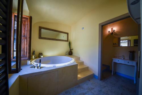 渥尔特拉Il Sogno di Annalisa Suite的带浴缸、水槽和楼梯的浴室