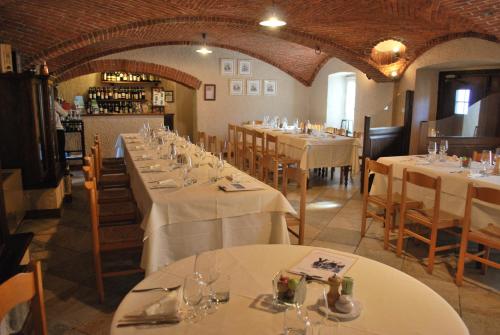 Bibiana伊尔弗鲁托佩美索农家乐的用餐室配有带白色桌布的桌子