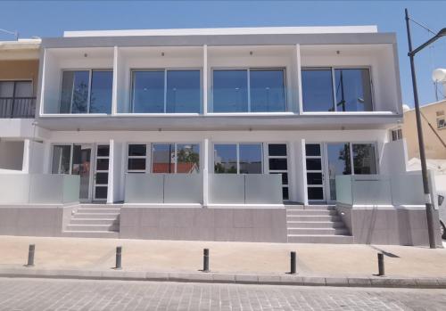 阿依纳帕Shalos Studios的一座大型白色建筑,设有玻璃窗