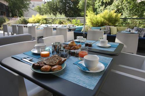 瓦朗斯法兰西酒店的一张桌子,早餐包括咖啡和糕点