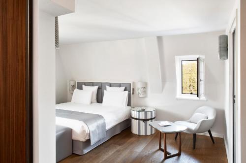 斯特拉斯堡Pavillon REGENT PETITE FRANCE的白色卧室配有床和椅子