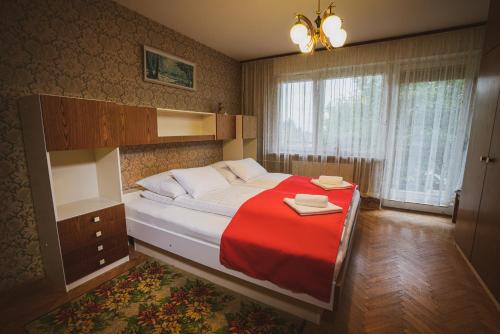 Spodnje GorjeApartmaji Retro的一间卧室配有一张带红色毯子的大床