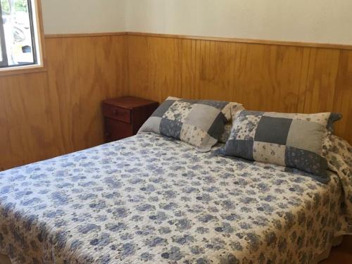 拉佩尔湖Cabañas La Puntilla Lago Rapel的一间卧室配有一张带两个枕头的床