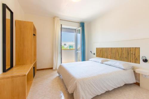 托雷桑塔萨宾娜Appartamento Cristallo的一间卧室配有一张床、一个梳妆台和一扇窗户。