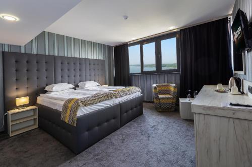 鲁塞里加大酒店的一间卧室配有一张床和一张带水槽的书桌