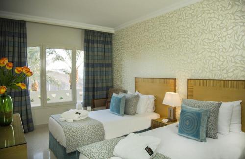 塔巴Taba Sands Hotel & Casino - Adult Only的酒店客房设有两张床和窗户。