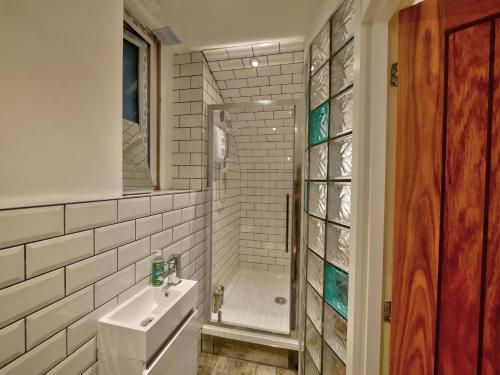 霍姆弗斯Pell Dell Apartment的带淋浴和盥洗盆的白色浴室