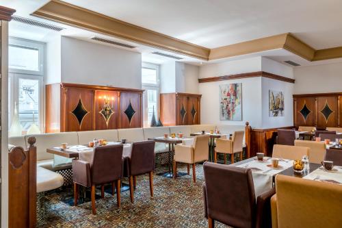 萨尔茨堡米拉贝尔广场奥斯超泰尔酒店的一间在房间内配有桌椅的餐厅