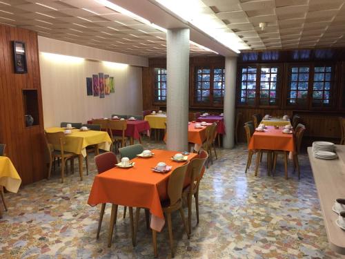 布里昂松布里松山酒店的用餐室配有桌椅和黄色及橙色的桌子