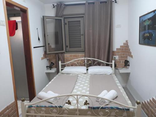 海法塔梅宾馆的一间小卧室,卧室内配有一张床铺