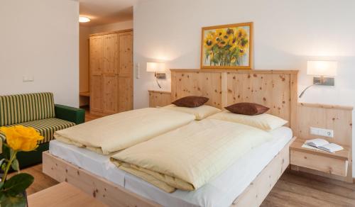 拉布拉Garni Appartment Wagnerhof的一间卧室配有一张大床和木制床头板