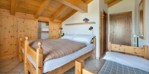 瓦尔迪索托Hotel Gallo Cedrone的卧室配有一张床铺,位于带木墙的房间内