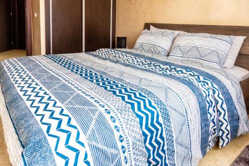 卡萨布兰卡全景公寓的一张带蓝色和白色棉被的床