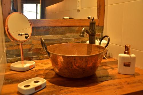 卡梅隆CABAÑA LA TOSCANA的浴室水槽设有铜 ⁇ 和镜子