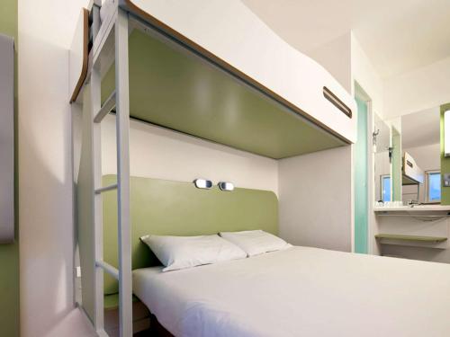 朴次茅斯Ibis Budget Portsmouth的一间卧室配有一张双层床和绿色的墙壁