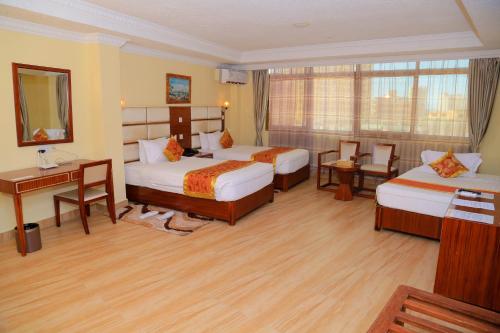 达累斯萨拉姆Tiffany Diamond Hotels Ltd - Indira Gandhi street的酒店客房配有两张床和一张书桌