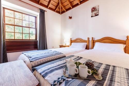 蓬塔戈尔达EL MIRADOR的卧室内的两张床,配有一个装有杯子的托盘