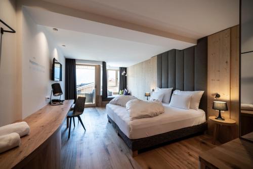 多比亚科欣帕蒂酒店的一间卧室配有一张大床和一张书桌