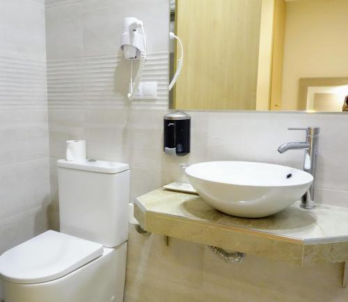 托莱多托莱多旅馆的白色的浴室设有水槽和卫生间。