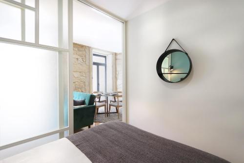 波尔图HM - Pinheiro Downtown Living的卧室配有一张床,墙上设有镜子
