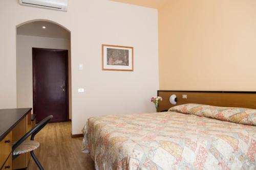 莱萨白羊座酒店的一间卧室配有一张床和一个梳妆台