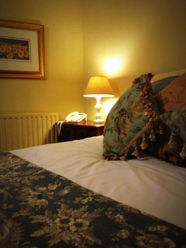 马基特博斯沃思Softleys的一张带枕头的床和一张桌子上的台灯