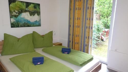 维也纳Luna Apartments的一间卧室配有一张带绿色枕头的床和一扇窗户